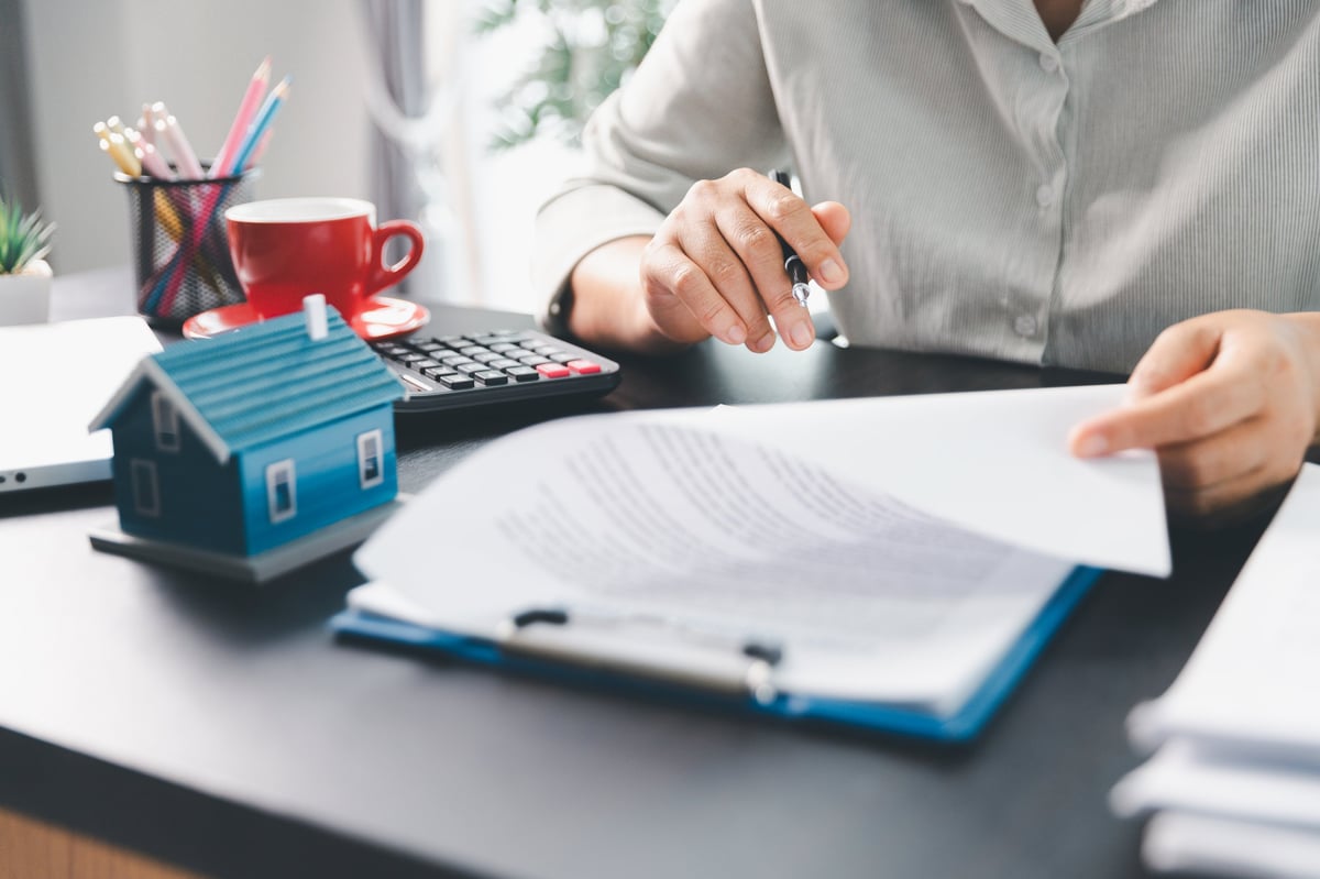 Real estate agent and clients reviewing a home purchase contract and insurance